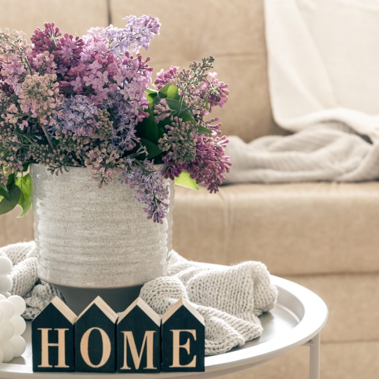 Composition with lilac flowers, candles and decorative word home.