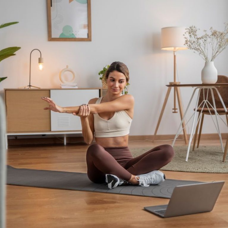 female-fitness-instructor-using-laptop-teach-class-from-home