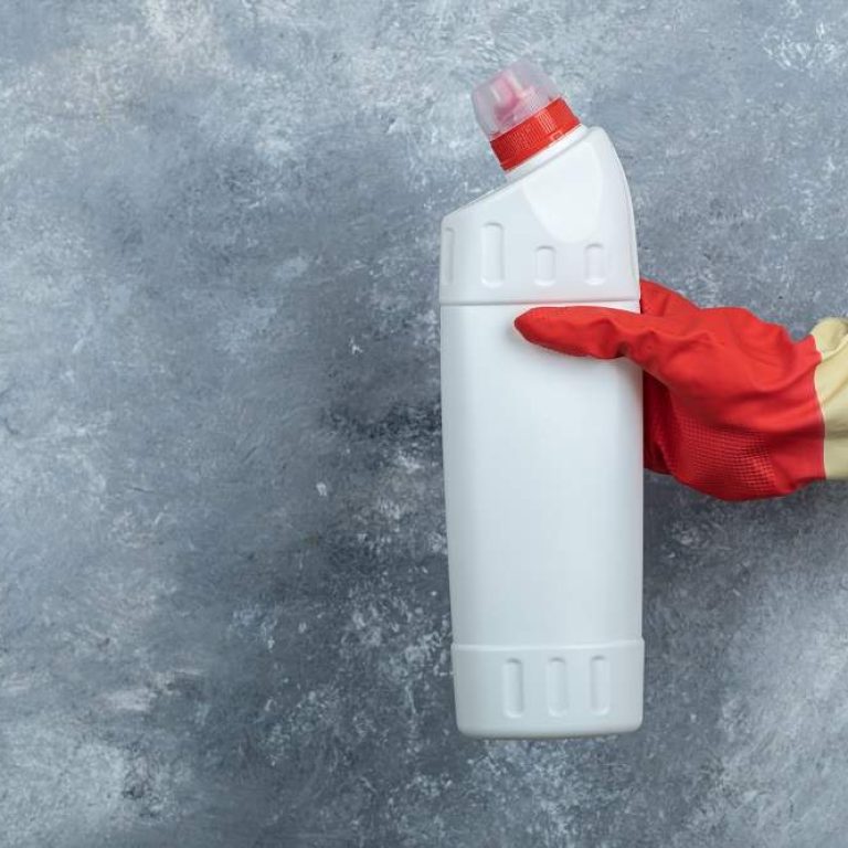 Female hand holding detergent on marble background. High quality photo