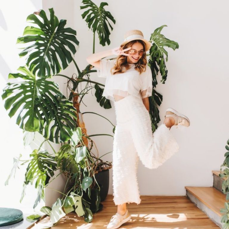 funny-young-lady-trendy-pants-standing-one-leg-showing-peace-sign-with-smile