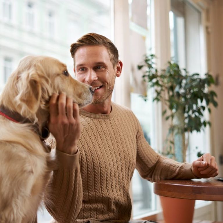 lifestyle-photo-young-handsome-man-entrepreneur-working-cafe-laptop-while-his-dog-sits