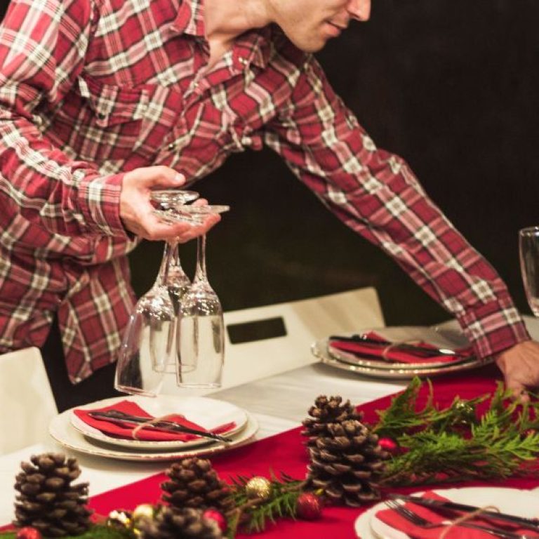 man-holding-champagne-glasses-while-decorating-table