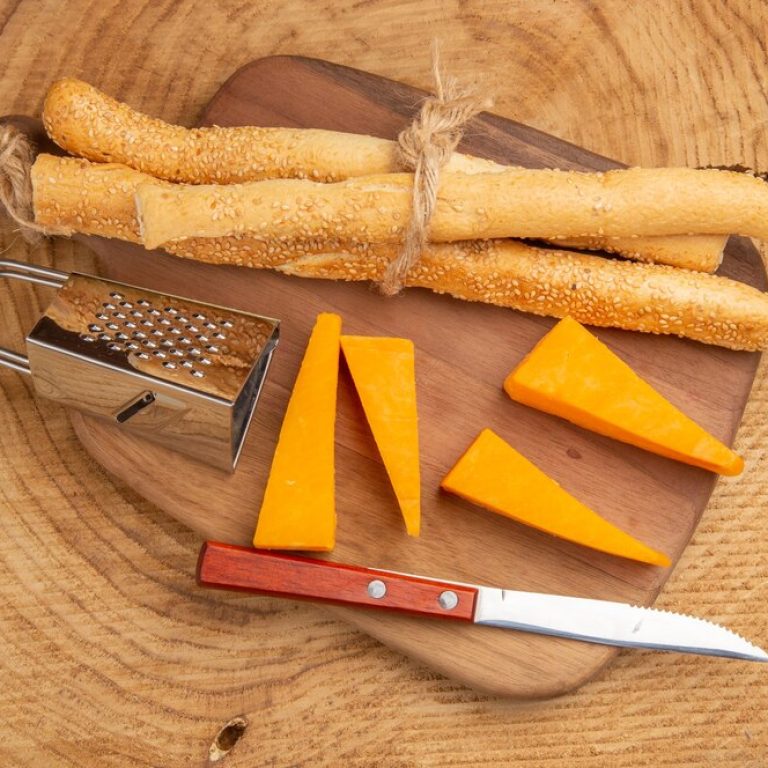 top-view-cheese-bread-knife-small-grater-cutting-board_140725-100004
