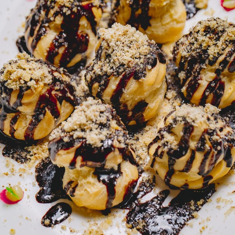 top-view-dessert-profiteroles-with-chocolate-icing-grated-nuts